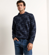 Load image into Gallery viewer, Man wearing a camouflage-patterned pullover hoodie with blue jeans and a belt