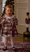 Load image into Gallery viewer, Toddler girl wearing a festive plaid dress with lace collar and trim, holding a brass horn