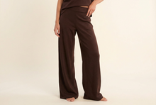 Load image into Gallery viewer, Woman wearing wide leg lounge pants with a relaxed fit and clean seam detailing