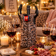 Load image into Gallery viewer, Leopard print faux fur wine tote bag displayed on a cozy girls night tablescape with charcuterie and wine glasses.