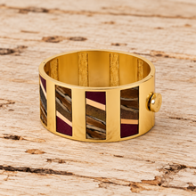 Load image into Gallery viewer, Brackish Cora Striped Hinge Cuff featuring gold metal frame with inlaid feather and mixed material panels