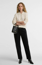 Load image into Gallery viewer, Woman wearing a classic knit polo sweater with button placket and collar, paired with black trousers