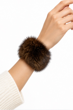 Load image into Gallery viewer, Fluffy dark brown fox fur cuff bracelet worn on a wrist over cream knit sleeve