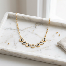Load image into Gallery viewer, Brackish Zoe Necklace featuring moon phase medallions on a delicate chain, displayed on marble