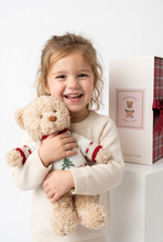 Load image into Gallery viewer, Smiling child hugging a plush Christmas Bear wearing a festive holiday sweater, with gift box