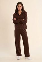 Load image into Gallery viewer, Woman wearing matching wide-leg lounge pants and zip-up hoodie set with white sneakers