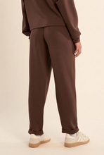 Load image into Gallery viewer, Back view of relaxed-fit sweatpants with rolled cuffs, paired with sneakers