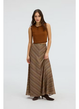 Load image into Gallery viewer, Model wearing a maxi length chevron patterned skirt in warm brown tones with kitten heels