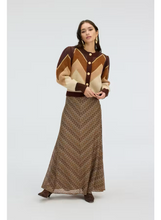 Load image into Gallery viewer, Model wearing a long maxi skirt with zigzag pattern paired with a chevron cardigan