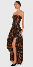 Load image into Gallery viewer, Model wearing strapless high-low floral jacquard gown with dramatic draped skirt and structured bodice