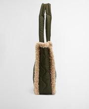Load image into Gallery viewer, Side view of quilted olive tote bag with shearling trim and structured handles