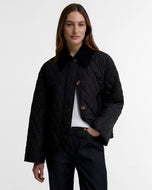 Woman wearing a quilted diamond-pattern jacket with corduroy collar and tortoiseshell buttons