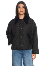 Load image into Gallery viewer, Woman wearing a black quilted jacket with corduroy collar and brass buttons, paired with jeans