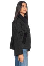 Load image into Gallery viewer, Woman wearing a black quilted jacket with corduroy collar and button front closure, side view