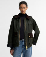Model wearing Barbour Carville wax jacket with corduroy trim, hood, and gold hardware