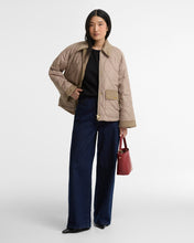 Load image into Gallery viewer, Model wearing a quilted diamond-pattern jacket with corduroy collar and cuffs, styled with wide-leg jeans