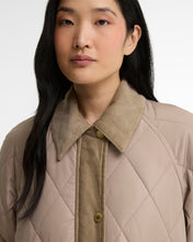 Load image into Gallery viewer, Close-up detail of quilted jacket with corduroy collar and gold snap buttons on model
