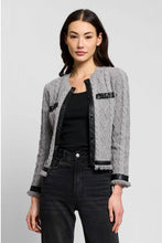 Load image into Gallery viewer, Woman wearing a grey cable-knit cardigan with black leather trim and turnlock details