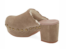 Load image into Gallery viewer, Back view of a taupe suede clog mule with shearling lining, studded trim, and block heel