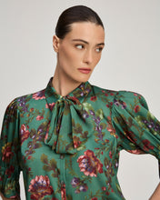 Load image into Gallery viewer, Model wearing green floral silk blouse with bow neckline and puffed three-quarter sleeves
