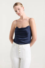 Load image into Gallery viewer, Model wearing a navy satin cowl-neck camisole with thin straps and white high-waist trousers