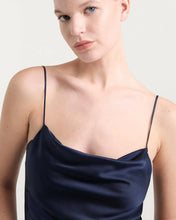 Load image into Gallery viewer, Close-up of a navy satin cowl-neck cami with thin spaghetti straps on a model