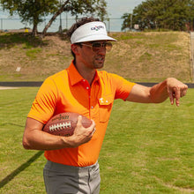 Load image into Gallery viewer, Man wearing orange Criquet polo shirt holding a football on a grass field