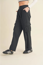 Load image into Gallery viewer, Women's lightweight nylon cargo pants with side pockets and elastic waistband, styled with sneakers
