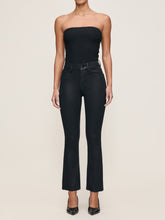 Load image into Gallery viewer, Model wearing high-rise cropped boot-cut coated jeans with a black strapless ribbed bodysuit and heels