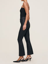 Load image into Gallery viewer, Side view of cropped bootcut coated jeans with raw hem worn with black slingback heels