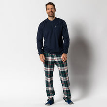 Load image into Gallery viewer, Man wearing navy long-sleeve top with green plaid flannel lounge pants and blue socks