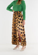 Load image into Gallery viewer, Model wearing a maxi wrap skirt in bold leopard print with front slit detail