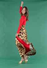 Load image into Gallery viewer, Model twirling in a leopard print maxi skirt with red lining and red long-sleeve top