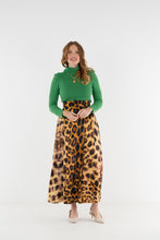 Load image into Gallery viewer, Model wearing a flowing midi skirt with bold leopard animal print pattern paired with green turtleneck