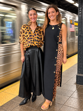 Load image into Gallery viewer, Two women posing at a subway station, one wearing a leopard print blouse with black skirt