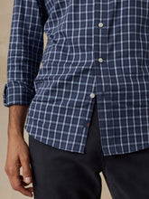 Load image into Gallery viewer, Close-up detail of navy plaid button-front shirt with white buttons and small brand tag