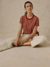 Load image into Gallery viewer, Model seated cross-legged wearing wide-leg cream denim pants with visible seam detailing