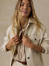 Load image into Gallery viewer, Model wearing an oversized cream denim jacket with contrast stitching over a striped shirt