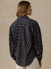 Load image into Gallery viewer, Back view of a woman wearing a navy floral printed long-sleeve button-down blouse