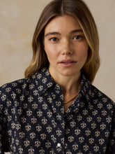 Load image into Gallery viewer, Woman wearing a navy button-up blouse with small cream floral blossom pattern, close-up view