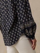 Load image into Gallery viewer, Close-up detail of navy floral print blouse sleeve with decorative border cuff trim