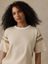 Load image into Gallery viewer, Woman wearing an oversized short-sleeve jersey tee with striped sleeve detail and ribbed collar