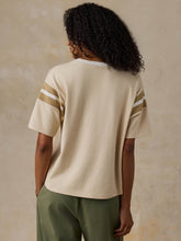 Load image into Gallery viewer, Back view of model wearing oversized short-sleeve jersey tee with varsity sleeve stripes