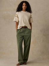 Load image into Gallery viewer, Model wearing oversized cream sport jersey tee with stripe detail on sleeves, full-length view