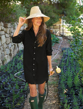 Load image into Gallery viewer, Woman wearing black button-down shirtdress with straw hat and green boots in garden