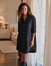 Load image into Gallery viewer, Model wearing a black button-front shirtdress with rolled sleeves and knee-high boots