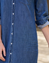 Load image into Gallery viewer, Close-up detail of a denim maxi shirtdress showing white snap buttons and chest pocket