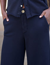 Load image into Gallery viewer, Close-up detail of navy cropped trouser sweatpant with side pockets and shirt overlay