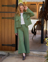 Load image into Gallery viewer, Model wearing wide-leg crop sweatpant with matching jacket at stable entrance