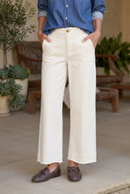 Load image into Gallery viewer, Model wearing wide-leg cropped white sweatpant trousers with brown loafers and denim shirt